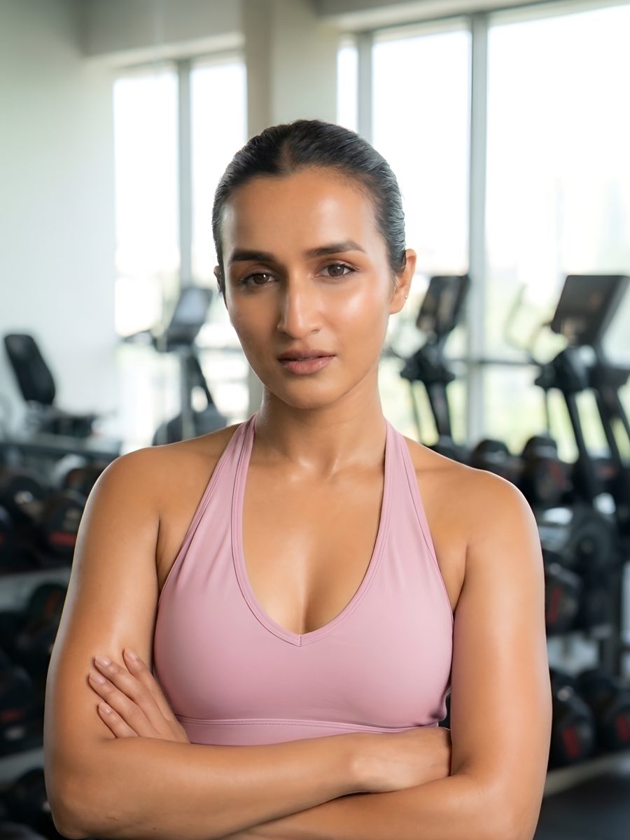 Jithmi Maligaspe in a pink sports top, arms folded, in a gym